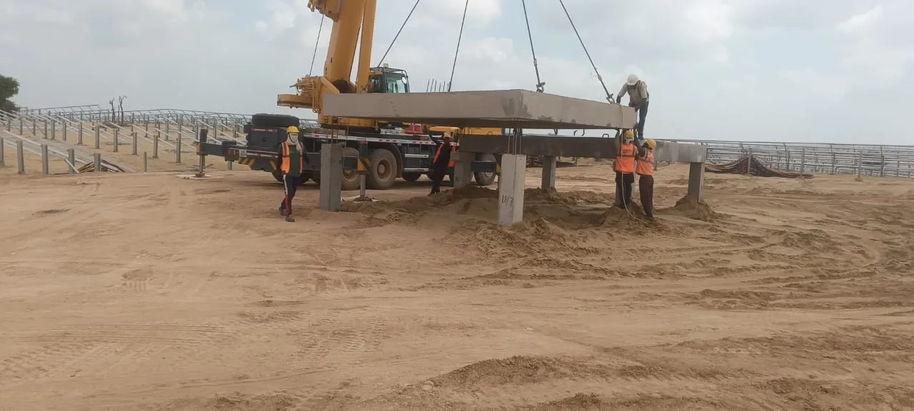 Crane lowering a precast beam onto column corbels — Fortico Infra solar project site