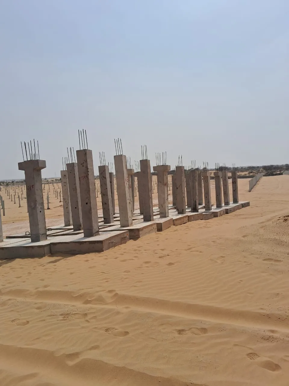 Long run of installed precast columns awaiting beams — Fortico Infra solar project site