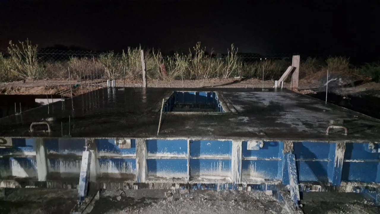 Precast column line under floodlight during night erection — Fortico Infra solar project site