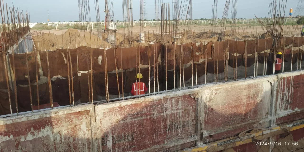 Excavated foundation pits with reinforcement crews — Fortico Infra solar project site