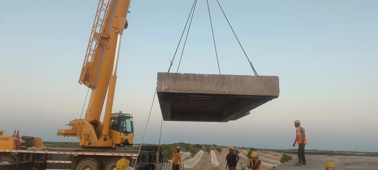 Crane handling a large precast wall unit — Fortico Infra solar project site